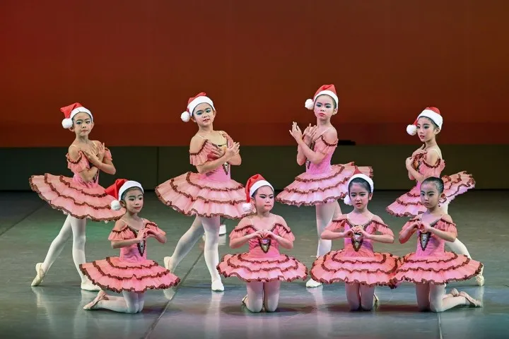 2018年の公演。サンタ帽とコーラルピンクのチュチュをまとった幼児から小学生9名ほどが決めポーズをとる群舞