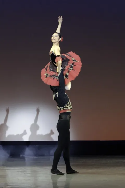 2022年の公演。黒衣装の男性が、赤と黒のチュチュの女性を肩の高さまで持ち上げるリフト